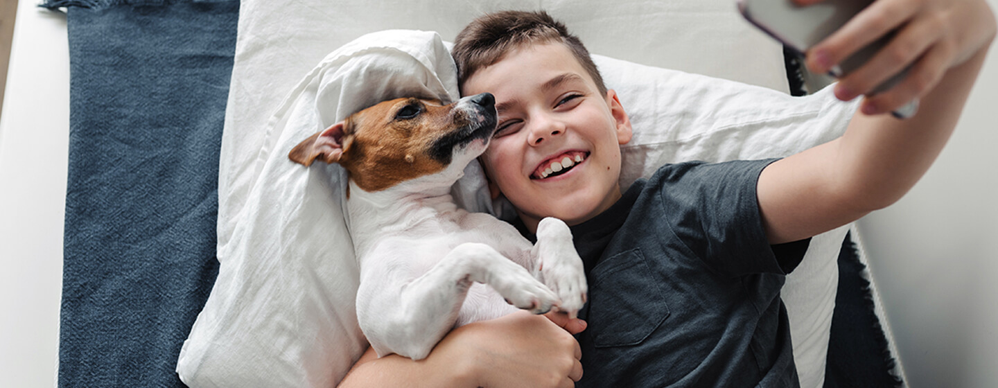 boy taking a selfie with his dog